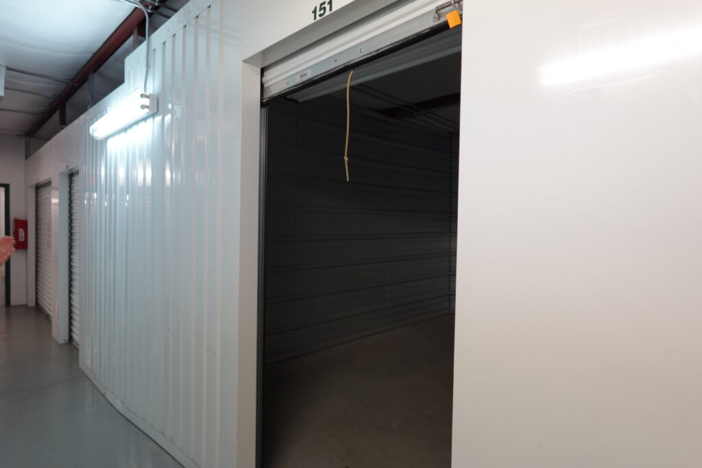 Inside our Climate Controlled Self Storage Unit with 24/7 Access - Photo depicts empty clean and well lit storage unit with white walls.